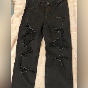 American Eagle. Black stretchy jeans…fashion cut holes through out legs.